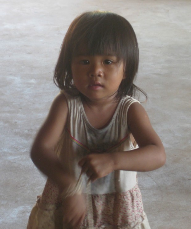 Although this young Cambodian girl had sweets to sell, she was helping her mother and is not one of the multitudes of orphans found here.